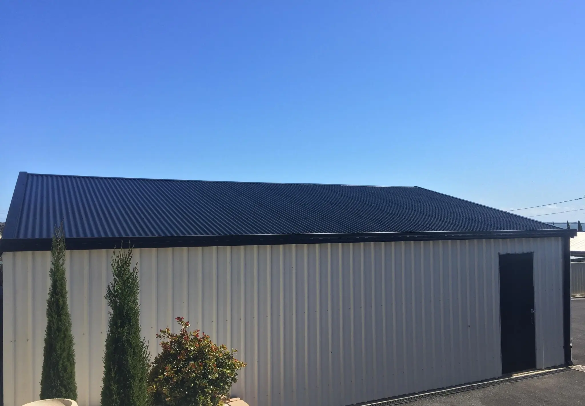 Dark coated metal roof on a large outbuilding